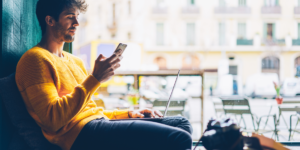 man shopping online on laptop and mobile phone